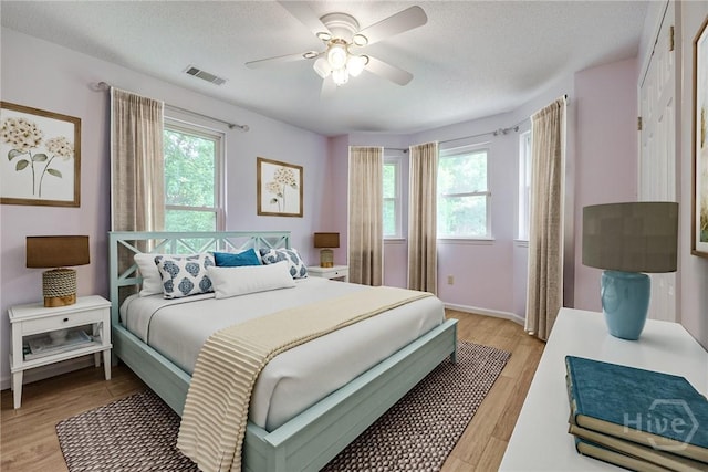 1 Shipyard Ln, Savannah, GA 31406 - bedroom with light wood-style floors, a ceiling fan, a textured ceiling, and baseboards
