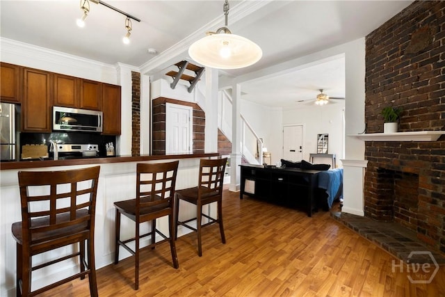 1402 Jefferson St, Savannah, GA 31401 - kitchen with appliances with stainless steel finishes, a breakfast bar, ceiling fan, light wood-style flooring, and dark countertops
