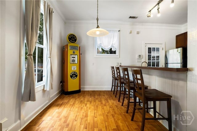 1402 Jefferson St, Savannah, GA 31401 - dining room with plenty of natural light, light wood finished floors, crown molding, baseboards, and rail lighting