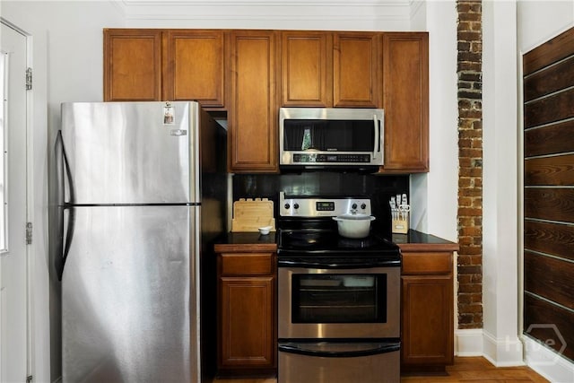 1402 Jefferson St, Savannah, GA 31401 - kitchen with stainless steel appliances, dark countertops, tasteful backsplash, brown cabinetry, and light wood-style floors