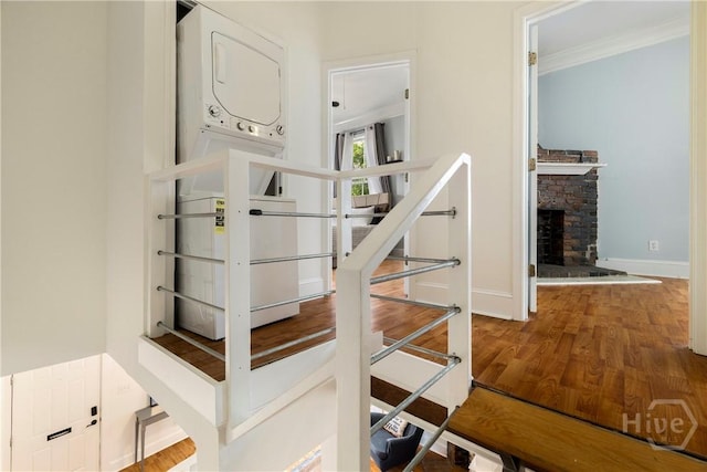 1402 Jefferson St, Savannah, GA 31401 - stairway featuring stacked washer / drying machine, ornamental molding, baseboards, wood finished floors, and a stone fireplace