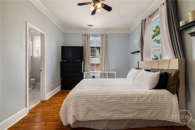 1402 Jefferson St, Savannah, GA 31401 - bedroom featuring multiple windows, ornamental molding, baseboards, ensuite bath, and wood finished floors