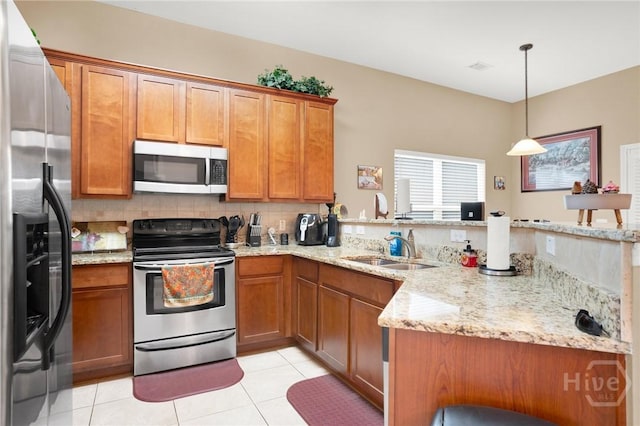 133 Moonlight Trl, Port Wentworth, GA 31407 - kitchen with appliances with stainless steel finishes, a sink, a peninsula, brown cabinets, and light stone counters