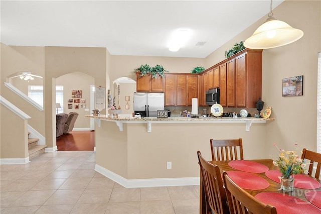 133 Moonlight Trl, Port Wentworth, GA 31407 - kitchen featuring appliances with stainless steel finishes, a peninsula, a breakfast bar, and brown cabinets