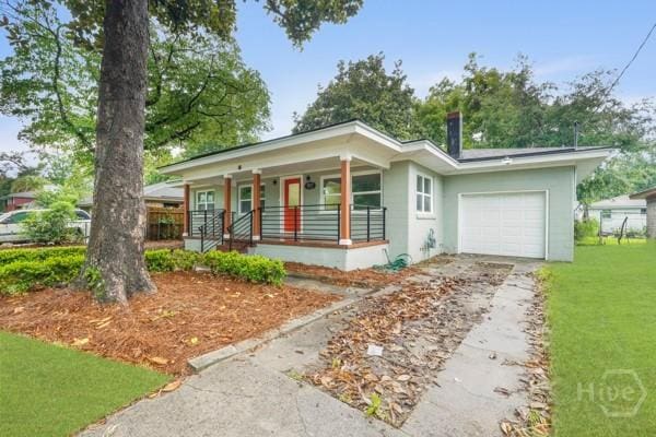 1817 Lloyd St, Savannah, GA 31405 - view of front of house with covered porch, driveway, a garage, a front lawn, and stucco siding