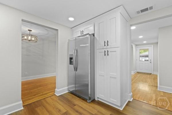 1817 Lloyd St, Savannah, GA 31405 - kitchen with stainless steel refrigerator with ice dispenser, white cabinetry, wood finished floors, a chandelier, and recessed lighting