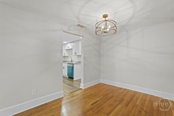 1817 Lloyd St, Savannah, GA 31405 - spare room with light wood-type flooring and a chandelier