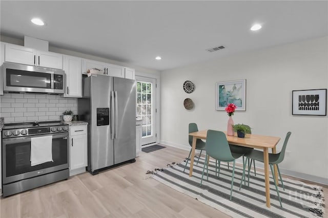 1220 E 69th St, Savannah, GA 31404 - kitchen with appliances with stainless steel finishes, white cabinets, baseboards, recessed lighting, and light wood finished floors
