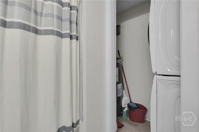1220 E 69th St, Savannah, GA 31404 - bathroom featuring estacked washer and dryer, wood finished floors, and curtained shower