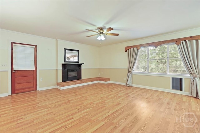 2317 Ga Highway 24, Statesboro, GA 30461 - unfurnished living room with light wood-type flooring, a glass covered fireplace, ceiling fan, crown molding, and baseboards