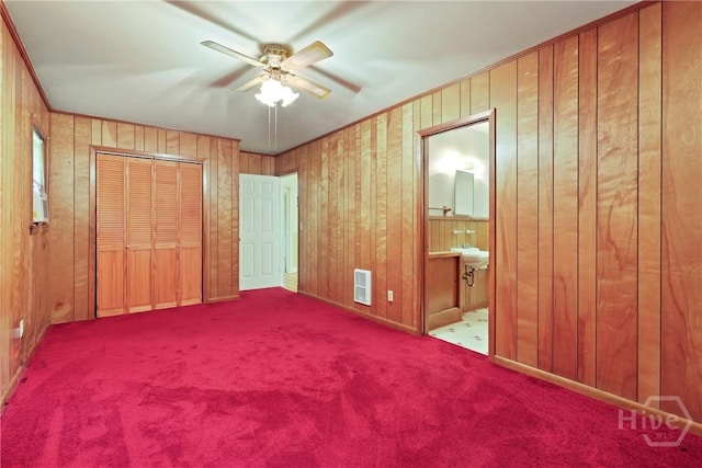 2317 Ga Highway 24, Statesboro, GA 30461 - unfurnished bedroom featuring carpet, wooden walls, a closet, connected bathroom, and a sink