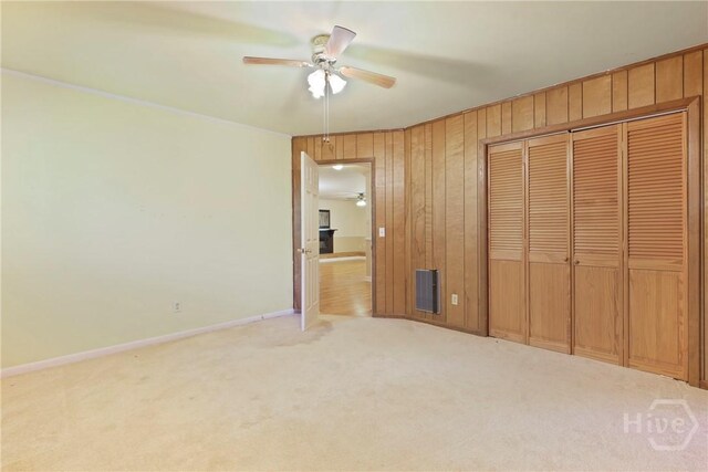 2317 Ga Highway 24, Statesboro, GA 30461 - unfurnished bedroom featuring carpet flooring, wood walls, a closet, baseboards, and a ceiling fan