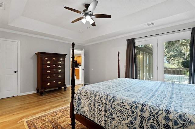 550 Strathy Hall Dr, Richmond Hill, GA 31324 - bedroom featuring access to exterior, a tray ceiling, light wood-style floors, baseboards, and a ceiling fan