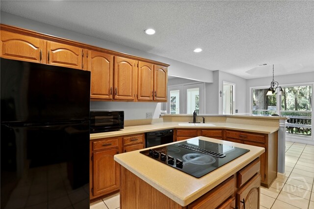 550 Strathy Hall Dr, Richmond Hill, GA 31324 - kitchen with black appliances, a sink, light tile patterned floors, light countertops, and brown cabinetry