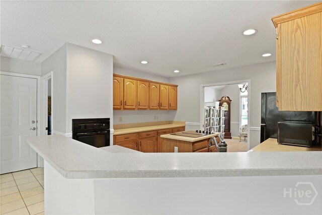 550 Strathy Hall Dr, Richmond Hill, GA 31324 - kitchen featuring black appliances, a center island, light countertops, light tile patterned floors, and recessed lighting