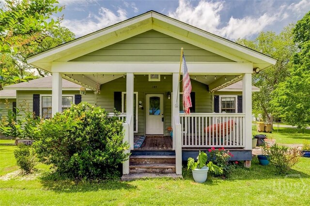 149 Spruce St, Richmond Hill, GA 31324 - view of front of house featuring covered porch and a front yard