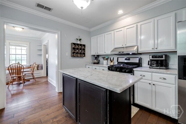 149 Spruce St, Richmond Hill, GA 31324 - kitchen featuring under cabinet range hood, dark wood-type flooring, white cabinetry, ornamental molding, and a center island