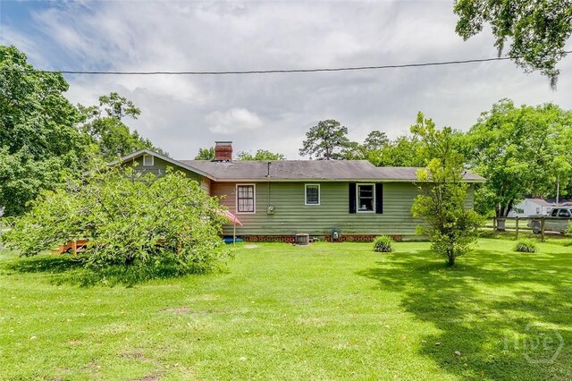 149 Spruce St, Richmond Hill, GA 31324 - rear view of house featuring a lawn and a chimney