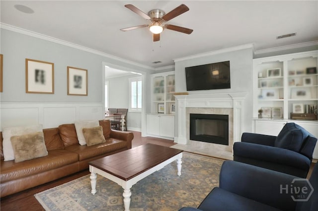 49 Tidewater Rd, Savannah, GA 31406 - living area with ornamental molding, ceiling fan, wood finished floors, a tiled fireplace, and built in shelves
