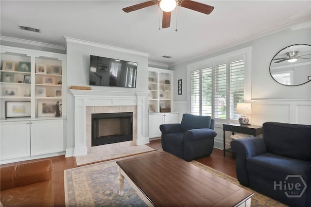 49 Tidewater Rd, Savannah, GA 31406 - living room featuring a ceiling fan, crown molding, wood finished floors, a tiled fireplace, and a decorative wall