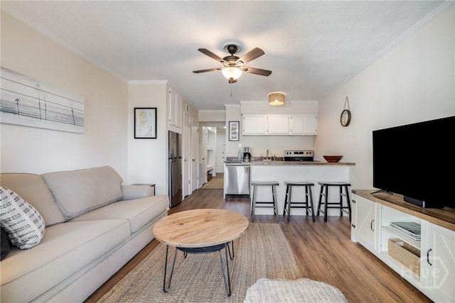 1217 Bay St Unit 105A, Tybee Island, GA 31328 - living room featuring wood finished floors, a ceiling fan, and crown molding