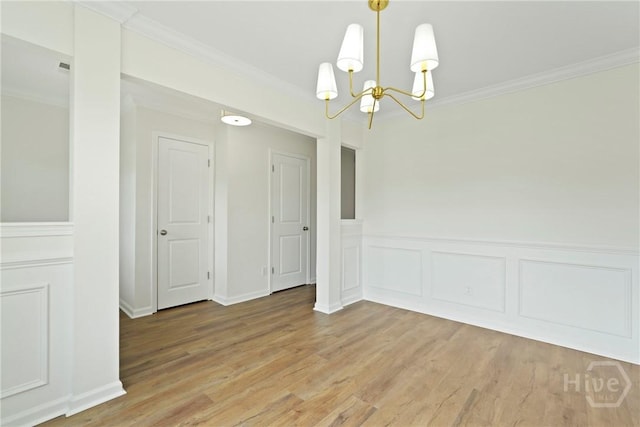 3 Chandler Bluff Dr, Savannah, GA 31407 - spare room featuring a chandelier, crown molding, light wood finished floors, a wainscoted wall, and a decorative wall
