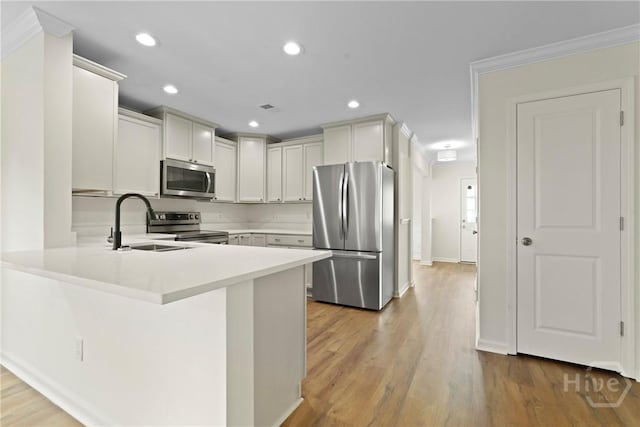 3 Chandler Bluff Dr, Savannah, GA 31407 - kitchen featuring appliances with stainless steel finishes, a peninsula, light countertops, recessed lighting, and light wood-style floors