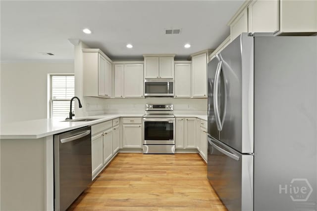 3 Chandler Bluff Dr, Savannah, GA 31407 - kitchen with stainless steel appliances, ornamental molding, light countertops, a peninsula, and light wood-style flooring