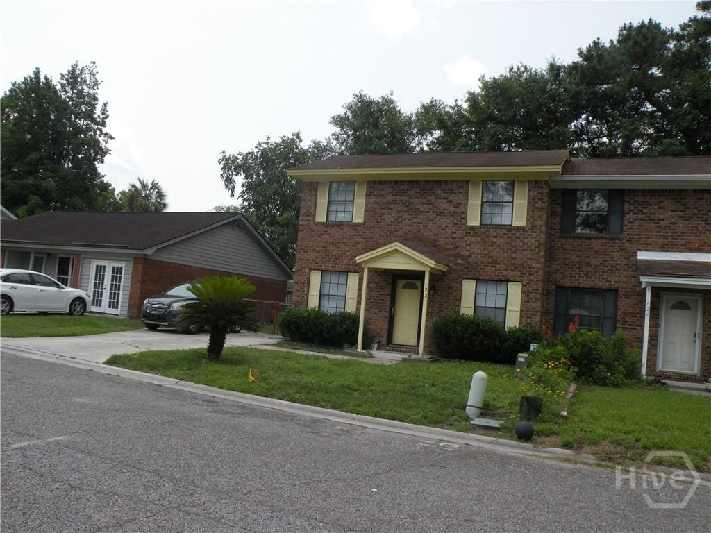 123 Hunt Club Ct, Savannah, GA 31406 - view of front facade featuring brick siding, a front yard, french doors, and driveway