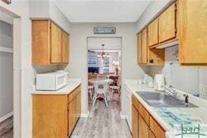 1000 New Sea Island Rd Unit 15, Saint Simons Island, GA 31522 - kitchen with light countertops, light wood finished floors, white microwave, and a chandelier