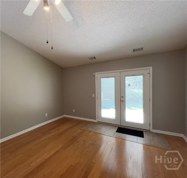 122 River Pointe Dr, Savannah, GA 31410 - unfurnished room featuring a textured ceiling, wood finished floors, french doors, and a ceiling fan