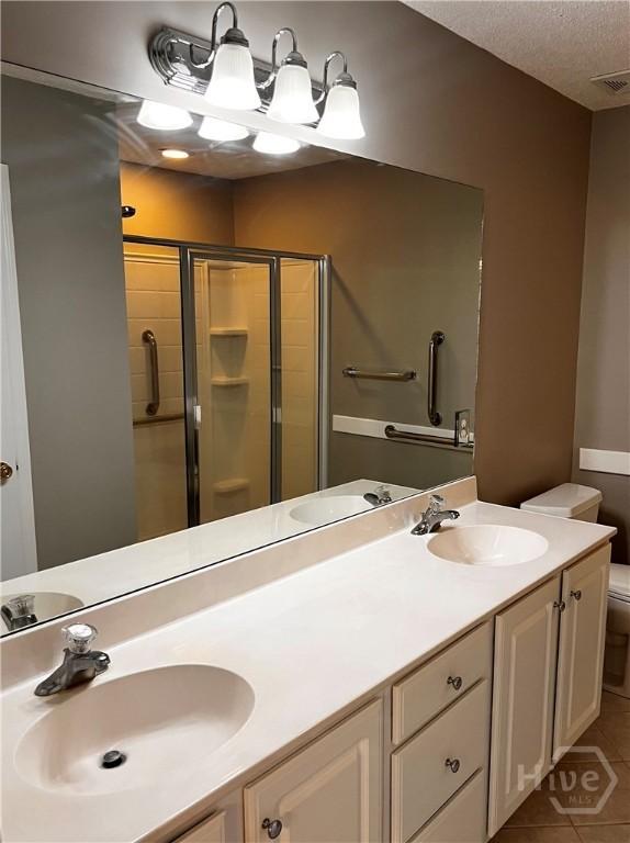 122 River Pointe Dr, Savannah, GA 31410 - full bathroom featuring double vanity, a stall shower, tile patterned floors, and a textured ceiling