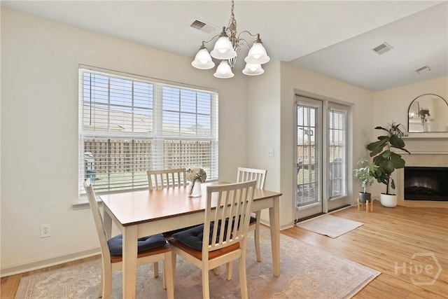 175 Willow Point Cir, Savannah, GA 31407 - dining space featuring a chandelier, light wood-type flooring, and a fireplace
