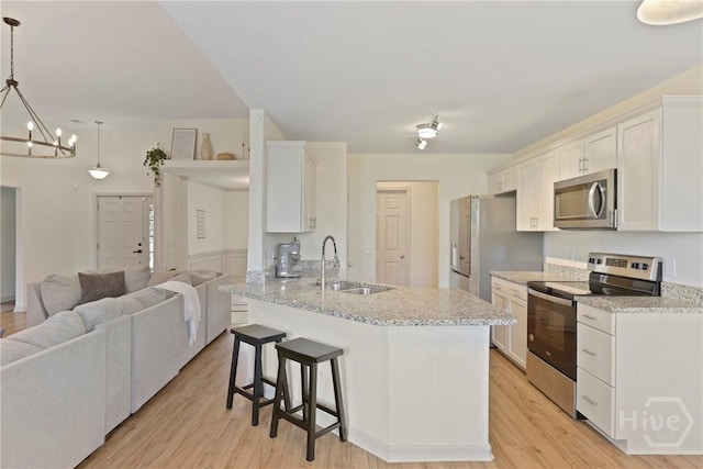 175 Willow Point Cir, Savannah, GA 31407 - kitchen featuring stainless steel appliances, open floor plan, a breakfast bar, white cabinetry, and light wood-style floors