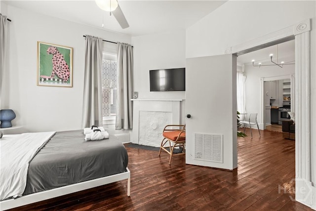 1212 Price St, Savannah, GA 31401 - bedroom with hardwood / wood-style floors, a fireplace with flush hearth, and a chandelier
