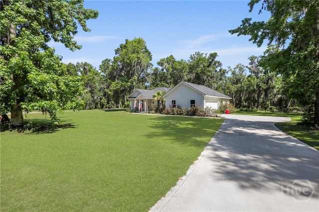 1003 Dolphin Ct, Townsend, GA 31331 - ranch-style home featuring a front lawn, asphalt driveway, an attached garage, and view of scattered trees