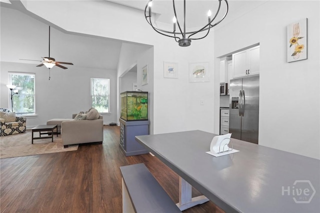 1003 Dolphin Ct, Townsend, GA 31331 - dining room featuring dark wood-style floors, a chandelier, a high ceiling, and a ceiling fan