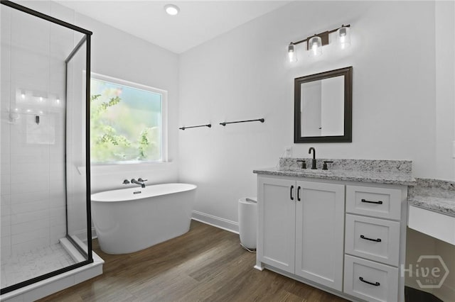 1003 Dolphin Ct, Townsend, GA 31331 - full bath featuring vanity, a shower stall, a freestanding tub, and wood finished floors