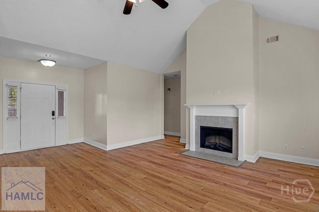 432 Cypress Creek Dr NE, Ludowici, GA 31316 - unfurnished living room with ceiling fan, wood finished floors, a tiled fireplace, and high vaulted ceiling