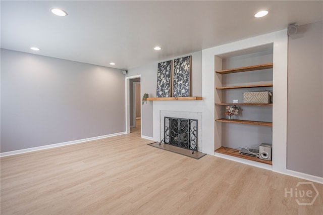 177 E Burkhalter St, Pembroke, GA 31321 - unfurnished living room featuring wood finished floors, a fireplace, recessed lighting, and built in features