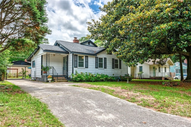 1915 Hawthorne St, Savannah, GA 31404 - ranch-style home featuring a chimney, an outdoor structure, a shingled roof, and a porch