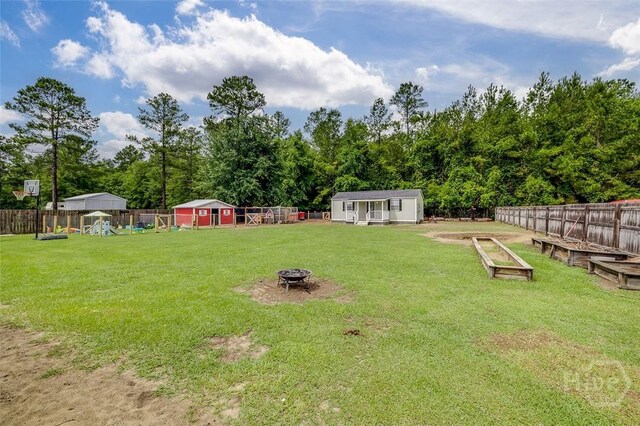 251 Old Louisville Rd, Guyton, GA 31312 - fenced backyard with an outbuilding, an outdoor fire pit, and a vegetable garden
