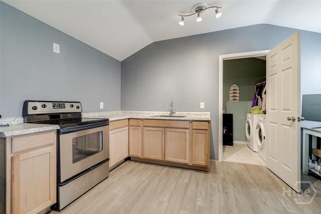 251 Old Louisville Rd, Guyton, GA 31312 - kitchen with washer and clothes dryer, electric stove, lofted ceiling, light wood finished floors, and light brown cabinets