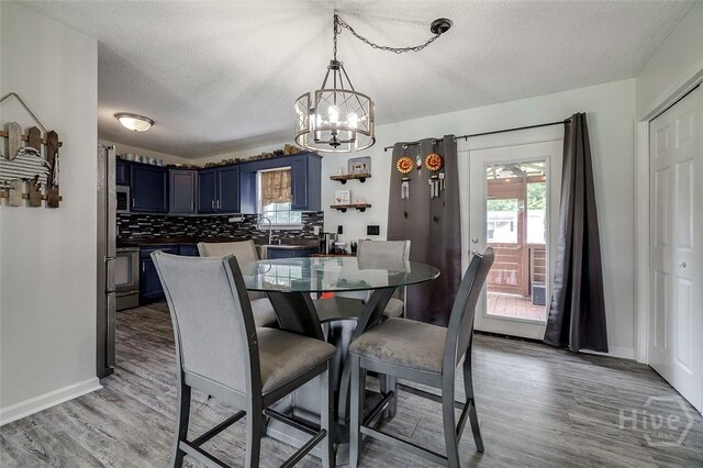 251 Old Louisville Rd, Guyton, GA 31312 - dining room with a chandelier, a textured ceiling, and light wood-style flooring