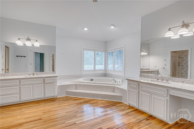4 Hedgewood Ln, Savannah, GA 31411 - full bathroom featuring two vanities, a bath, wood finished floors, and a shower stall