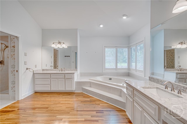 4 Hedgewood Ln, Savannah, GA 31411 - bathroom with a shower stall, wood finished floors, two vanities, and a garden tub