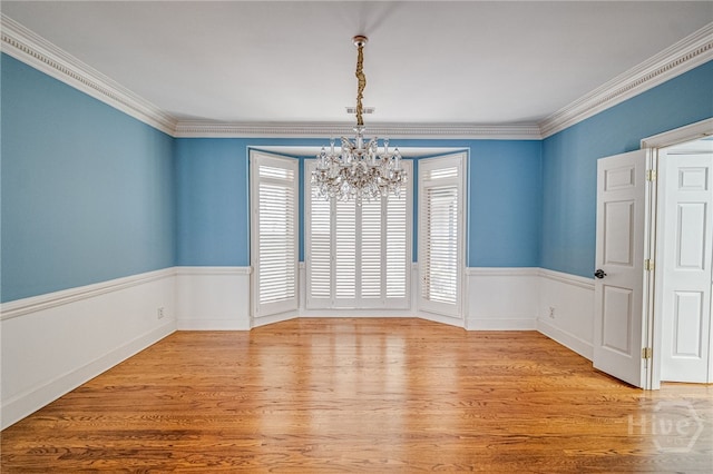 4 Hedgewood Ln, Savannah, GA 31411 - unfurnished room with a chandelier, light wood finished floors, crown molding, and a wainscoted wall