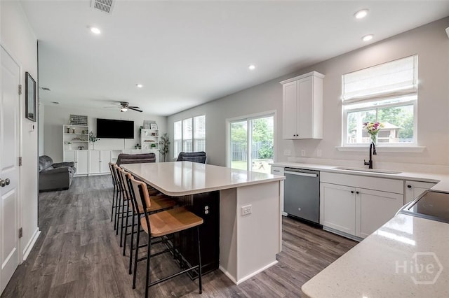 151 Excel Dr, Richmond Hill, GA 31324 - kitchen featuring stainless steel dishwasher, a kitchen island, white cabinetry, dark wood finished floors, and a kitchen breakfast bar
