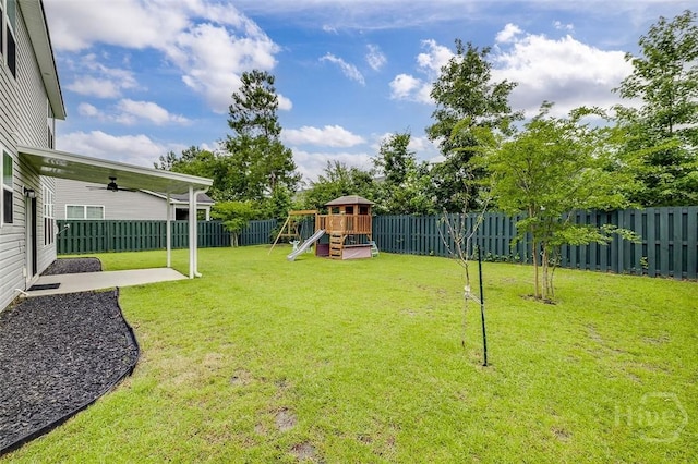 151 Excel Dr, Richmond Hill, GA 31324 - fenced backyard with a playground, ceiling fan, and a patio area