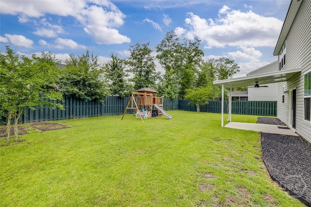 151 Excel Dr, Richmond Hill, GA 31324 - fenced backyard with a ceiling fan, a playground, and a patio area